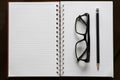 Pencil and glasses on open book with line on brown wood Royalty Free Stock Photo