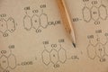 Pencil lies on the page of old chemistry book with chemical formulas