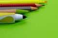Pencil, marker, ball pen close up macro shot on vibrant green background