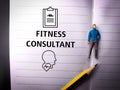 Pencil,miniature people and icon with text FITNESS CONSULTAN