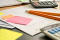 pencil and paper on a desk with sticky notes and a calculator beside Royalty Free Stock Photo