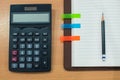 Pencil,paper note,calculator and notebook on wooden table. Top view