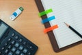 Pencil,post-it paper,calculator,usb and notebook on wooden table