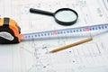 Pencil, ruler and magnifying glass on top of a plan