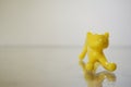 a pencil shaped yellow toy cat in a frontal angle, small, cute and curious