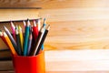 Pencil stand and a stack of books on wooden background. Copy space for the text. Royalty Free Stock Photo