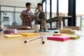 pencil and sticky note on table with background of young university students studying with tablet doing group study for school as Royalty Free Stock Photo