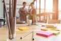 pencil and sticky note on table with background of young university students studying with tablet doing group study for school as Royalty Free Stock Photo