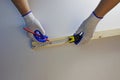 Pencil and tape measure in the hands of a carpenter, working with a wooden bar. White background Royalty Free Stock Photo