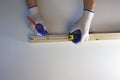 Pencil and tape measure in the hands of a carpenter, working with a wooden bar. White background Royalty Free Stock Photo