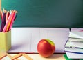 Pencil tray and an apple on notebooks on school teachers desk. Generative AI