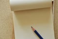 Pencil on white paper notebook on plywood desk