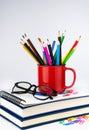 Pencils in a bright red mug and the books. School concept. Teacher`s Day. Selective focus Royalty Free Stock Photo