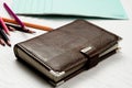 Pencils and brown leather diary lie on a white wooden table Royalty Free Stock Photo