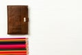 pencils and brown leather diary lie on a white wooden table Royalty Free Stock Photo