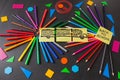 Pencils in circles, titles Back to school and drawing of school bus drawn on the pieces of paper on the chalkboard Royalty Free Stock Photo