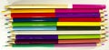 Pencils for drawing on paper of different colors lie on a white drawing paper