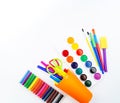 Pencils and felt-tip pens in a plastic cup, paints and pastel crayons on a white background Royalty Free Stock Photo