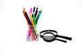 Pencils in a glass jar with a magnifying glass. Royalty Free Stock Photo