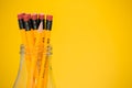 The pencils in a glass jar, yellow background