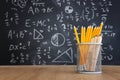 Pencils infront of blackboard with formulas. education concept Royalty Free Stock Photo