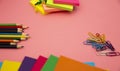 Pencils, multicolored papers and paper clips on a pink background Royalty Free Stock Photo