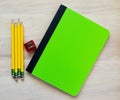 4 pencils, a pencil sharpener and a notebook with blank cover for customized message Royalty Free Stock Photo