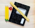 4 pencils, a pencil sharpener, a ruler and a notebook on a wooden desk Royalty Free Stock Photo