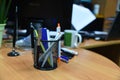 Pencils and pens  in plastic glass on the wooden table in the office. Plastic box for storing artificial objects, organizer for Royalty Free Stock Photo