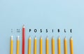 Pencils with the text impossible, stopping the domino effect. success and challenge concept