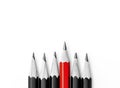 pencils on white, One red pencil standing out from the row of black pencils Royalty Free Stock Photo