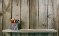 Pencils on a wooden shelf.