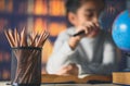 Pencils on a wooden table and asian child industrious is sitting at a desk . background. Educational background