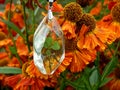 Pendant made of epoxy resin with clover on a background of flowers Royalty Free Stock Photo