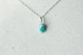 A pendant made of natural stone Turquoise silver chain. Author`s jewelry from natural stones. Designer jewelry. On a light modern Royalty Free Stock Photo