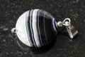 Pendant from striped polished Agate stone on black