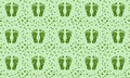 Repeating pattern of green leaf footprints on a subtle textured light green background. Royalty Free Stock Photo