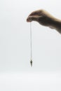 Pendulum dowsing on an isolated white background with a silver point Royalty Free Stock Photo