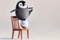 Penguin balancing on a ball on a chair. Space for text. Royalty Free Stock Photo