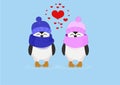 Penguin couple in hats and heart on a blue background Royalty Free Stock Photo