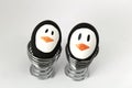 Penguin Easter Eggs on metal egg cup white background Royalty Free Stock Photo