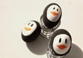 Penguin Easter Eggs on metal egg cup white background Royalty Free Stock Photo