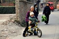 Pengzhou, China: Grandmother Teaching Child to Ride Bike