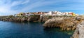 Panorama view of the jagged rocky coast and colorful houses in the center of Peniche