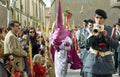 Penitent walking among people with palms and the music band in the Easter Week procession La Borriquita, on Palm Sunday in Zamora