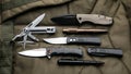 Penknives, multi-tools and tactical pens. Folding pocket knives on a khaki back