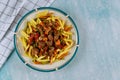 Penne pasta with beef stew with vegetable in plate on blue table Royalty Free Stock Photo