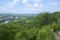 In early summer sunshine a woman considers the view over the Lot River and Valley from hilltop Penne d`Agenais