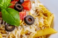 Penne and fusilli pasta with tomatoes, olive, parmesan and basil Royalty Free Stock Photo
