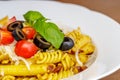 Penne and fusilli pasta with tomatoes, olive, parmesan and basil Royalty Free Stock Photo